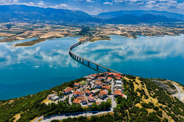 Aerial view of Lake Polyfytos in Greece with a curved bridge,
