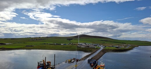 Kirkwall united kingdom aug 9 2024 Scenic Harbor View with Wind Turbine and Lush Green Landscape