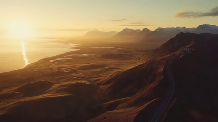Naklejka premium Icelandic coastal road at sunset with mountains and ocean in golden light