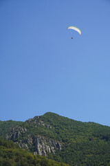 paragliding paragliding flight parachutist and beautiful mountain landscape blue sky forest trees Balkans Rhodope Bulgaria