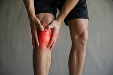 Close Up of Man Holding Knee in Pain with Red Highlight on Knee Joint Injury Concept and Health Issues