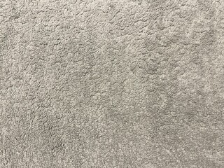 A close-up shot of a textured gray carpet, showcasing its fluffy and soft fabric loops.