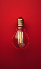 Glowing lightbulb on red background.  Ideas, innovation, and inspiration.