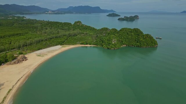Aerial view of a tropical island with a sandy beach, lush green vegetation, and turquoise waters, creating a vibrant contrast of colors, Langkawi Island, Kedah, Malaysia.
