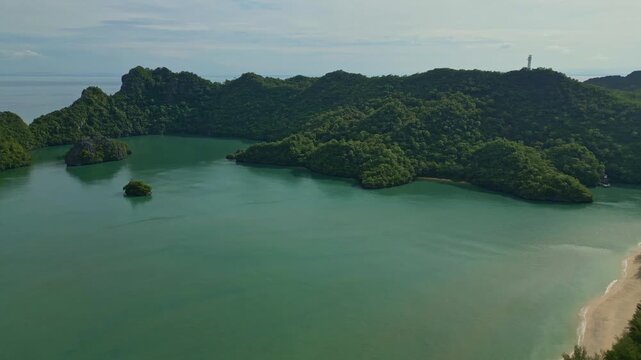 Aerial view of lush green tropical islands meet the turquoise sea, contrasting with the sandy beach, Langkawi Island, Kedah, Malaysia.
