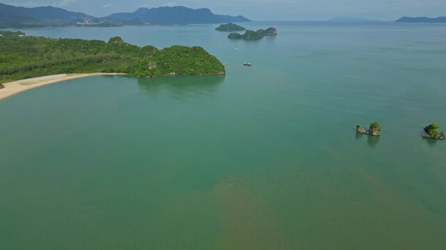 Aerial view of the tranquil turquoise ocean surrounding islands with lush green vegetation and sandy beaches, Langkawi Island, Kedah, Malaysia.