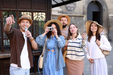 Guide with microphone and group of tourists on city street during excursion