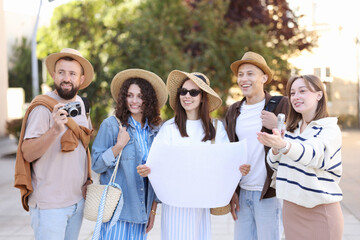 Guide with microphone and group of tourists on city street during excursion