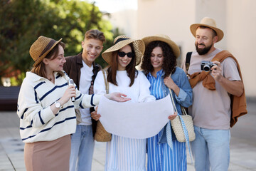Guide with microphone and group of tourists on city street during excursion