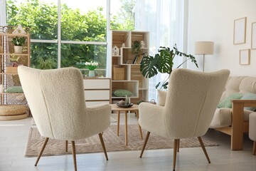 Comfortable armchairs and other furniture in living room. Interior design