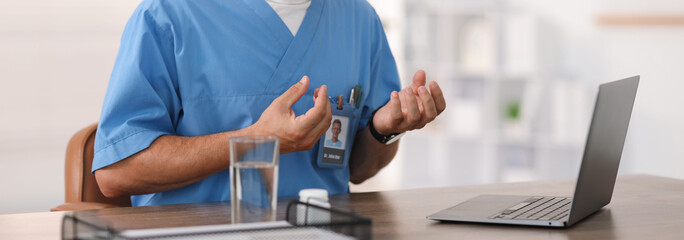 Telemedicine. Doctor having video call with patient via laptop indoors, closeup