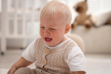 Portrait of little baby crying at home