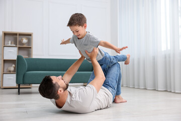 Father and his son spending time together on warm floor at home. Heating system