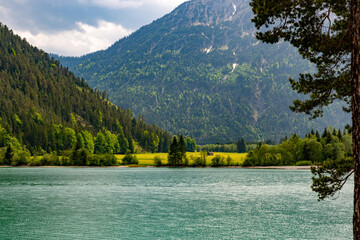 Fantastic view across the Heterwanger See to a meadow with a hut on the other side of the shore. In...