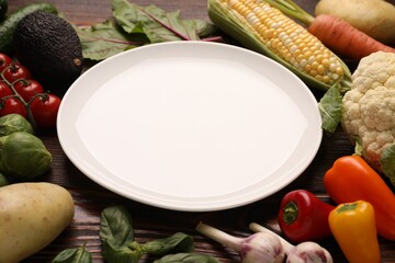 Healthy vegetarian food. Empty plate surrounded by different products on wooden table, closeup