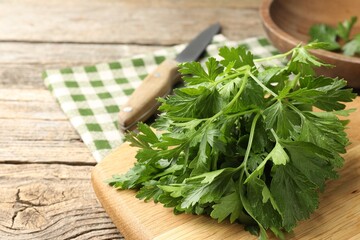 Bunch of fresh parsley and knife on wooden table, closeup