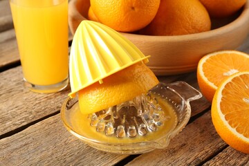 Juicer with fresh fruits and orange juice on wooden table, closeup