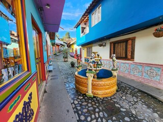 Naklejka premium Traditional fountain decorating a colorful street in guatape, colombia, showcasing the town's vibrant culture and architecture