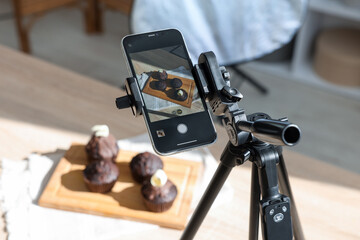 Obraz premium Shooting chocolate muffins with smartphone in studio, closeup. Professional food photography