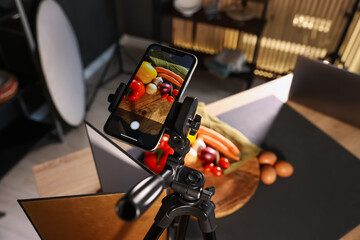 Shooting vegetables with smartphone in studio, focus on screen. Professional food photography