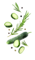 Fresh cucumbers, rosemary and peppercorns falling against white background