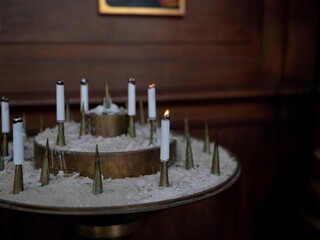 Contemplative prayer candles in sand arrangement with warm candlelight creating meditative religious atmosphere