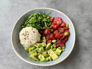 Fresh poke bowl with tuna, avocado, rice, and seaweed salad