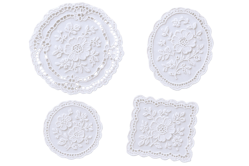 Four delicate white embroidered doilies with floral patterns, showcasing intricate lacework and decorative borders