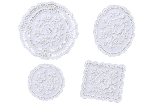 Four delicate white embroidered doilies with floral patterns, showcasing intricate lacework and decorative borders