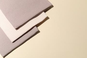 Clean waffle towels on beige background, top view. Space for text