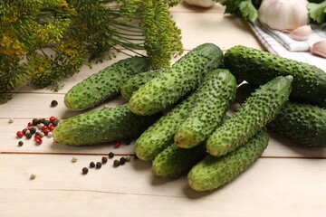 Making pickles. Fresh cucumbers, peppercorns and dill on light wooden table, closeup