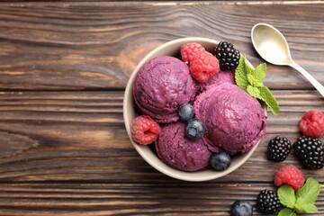 Delicious sorbet with fresh berries and mint in bowl on wooden table, flat lay. Space for text