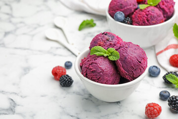 Delicious sorbet in bowl, fresh berries and mint on white marble table, closeup. Space for text