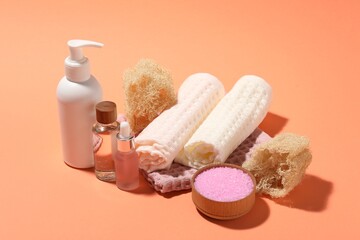 Clean waffle towels and spa products on coral background, closeup