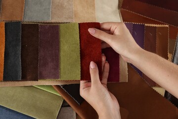 Woman choosing fabric among different samples indoors, top view