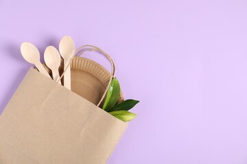 Different eco friendly packaging and leaves on violet background, flat lay. Space for text