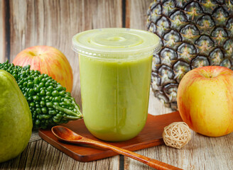 Fresh Bitter Melon Vegetable Juice with Pineapple, Apple, and Guava on Rustic Wooden Table for Healthy Living Side View