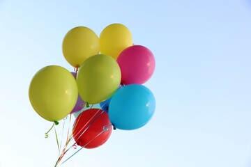 Bunch of colorful balloons under beautiful sky, low angle view