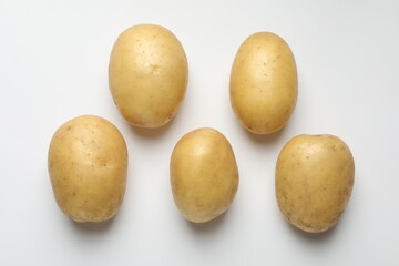 Fresh raw potatoes on light grey background, top view