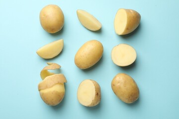 Fresh raw potatoes on light blue background, flat lay