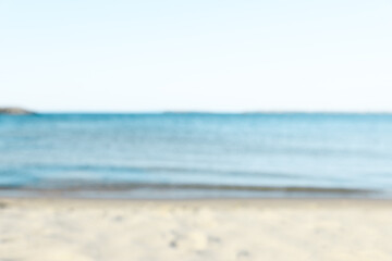 Beautiful sea and shore under light blue sky, blurred view