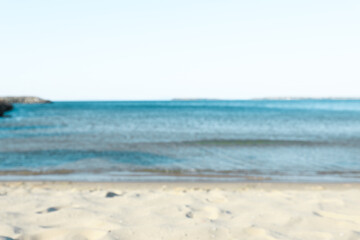 Beautiful sea and shore under light blue sky, blurred view