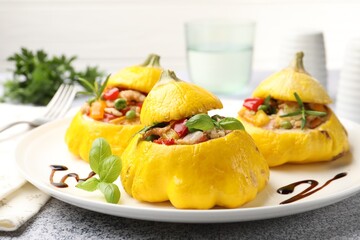 Tasty stuffed pattypan squashes on grey table, closeup