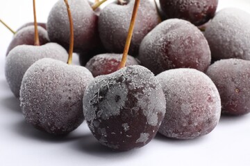 Many frozen cherries on white background, closeup