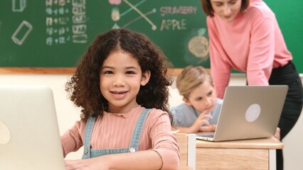 Attractive girl coding prompt while looking at camera at STEM class while happy teacher checking...