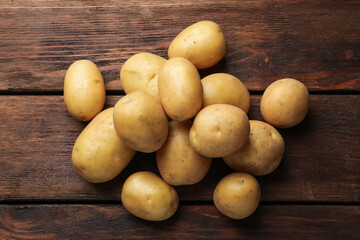 Pile of raw potatoes on wooden table, flat lay