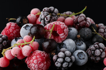 Many different frozen berries on black table, closeup