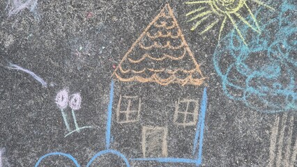 Imaginative and temporary chalk drawing of a cozy house, sun, clouds, and hearts on pavement....