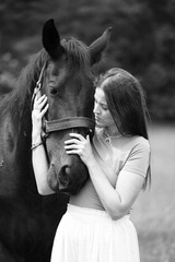 A young woman and her icelandic horse working and cuddle together. Woman lovingly pets a horse in a...