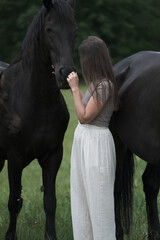 A young woman and her icelandic horse working and cuddle together. Woman lovingly pets a horse in a...